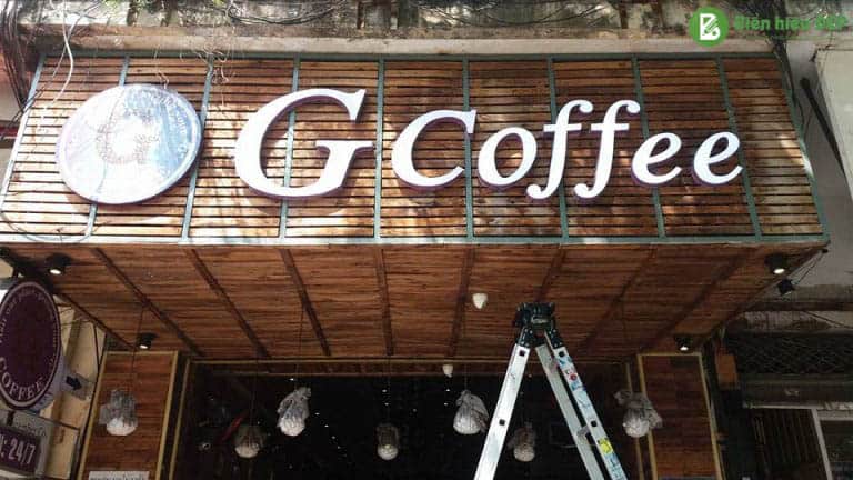 1.Quán cafe phong cách tối giản với biển hiệu mica chữ nổi tông trắng đen nổi bật trên nền gỗ