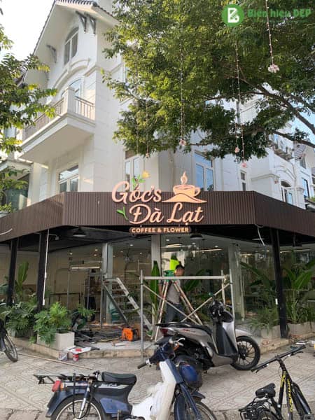 4.Nhân viên thi công đang lắp biển mica vào mặt tiền quán cafe
